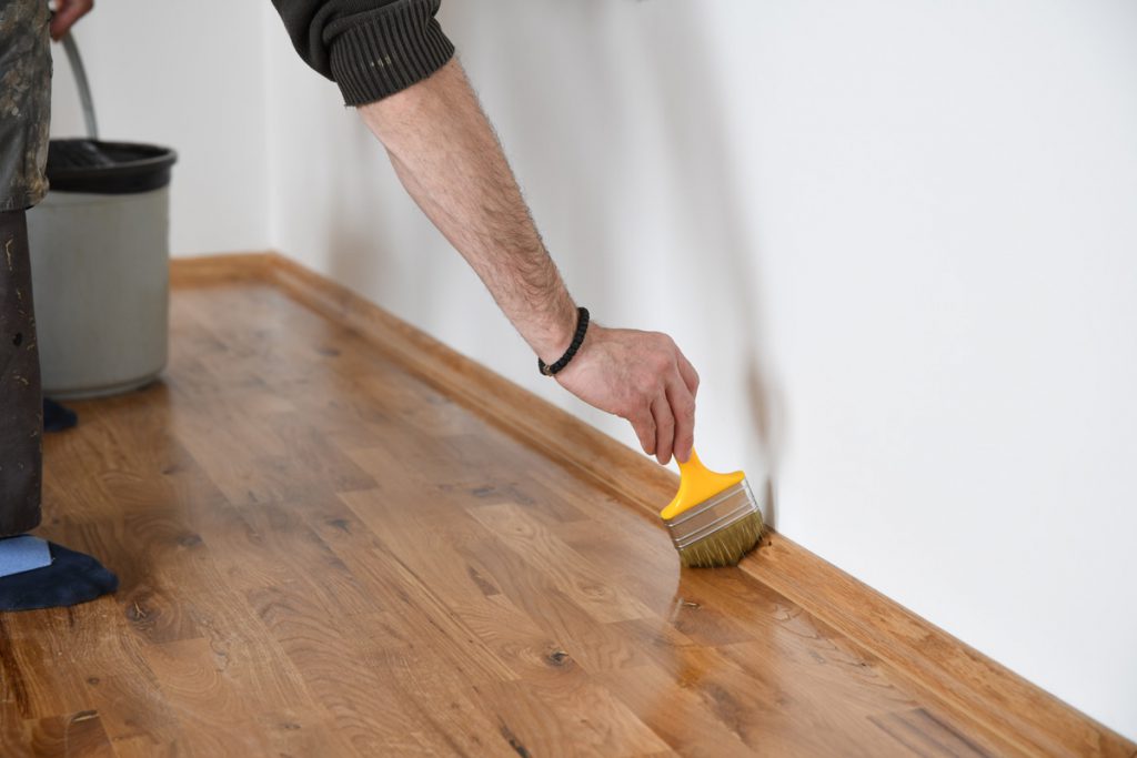 Renovácia masívnej podlahy z tvrdého dreva v interiéri, ošetrovanie parkiet olejom.
